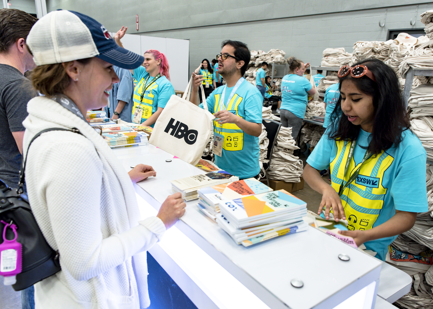 Volunteers hand out the big bags in Exhibit Hall 5.