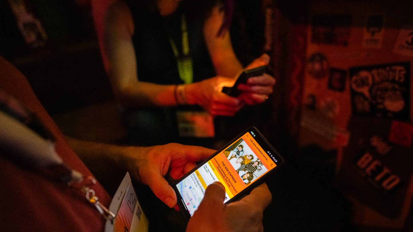 Attendee looking up a band on the SXSW GO app - Photo by Tico Mendoza